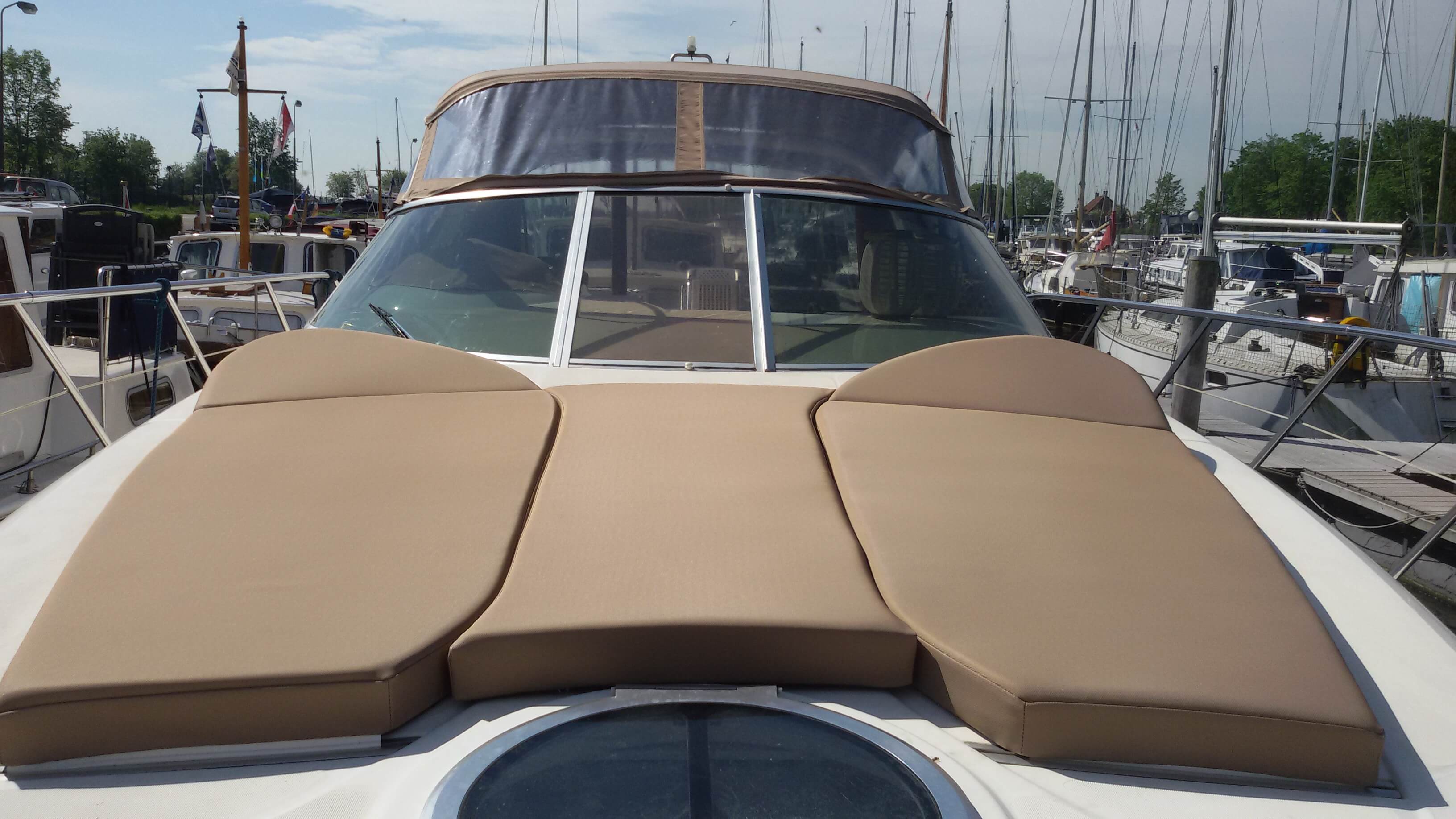 Zonnedek van een motorjacht met taupe maatwerkmatrassen